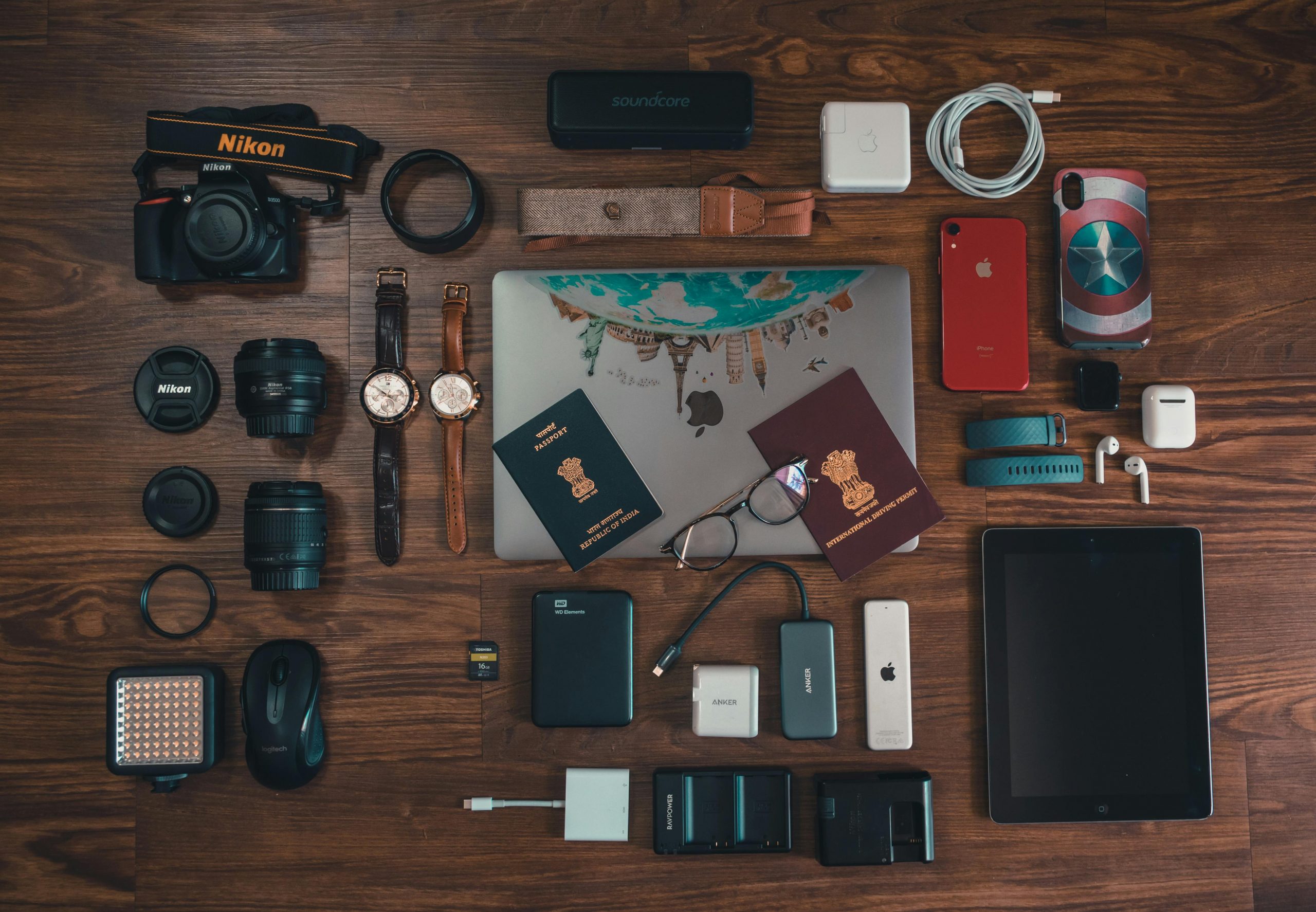 Flat lay of a smartphone, passport, and travel essentials on a wooden table